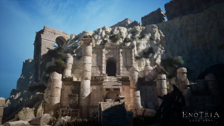 HD desktop wallpaper and background from the video game Enotria: The Last Song, featuring ancient stone ruins against a rugged mountainside under a clear blue sky.