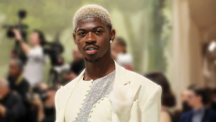 Lil Nas X in a stylish white outfit, set against a blurred background, captured in HD. This image is tagged with music and rapper, and serves as an HD desktop wallpaper and background.
