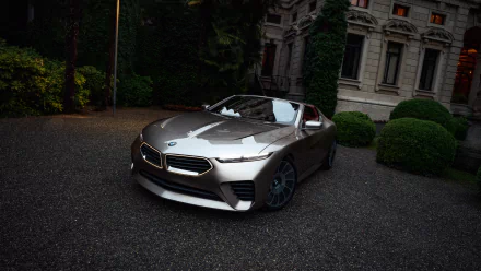 HD desktop wallpaper of a sleek BMW Skytop car, parked in a scenic setting with lush greenery and a majestic building in the background.