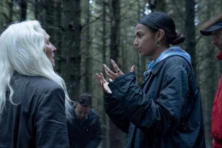 HD wallpaper featuring a scene from the 2024 movie The Watchers. Characters engage in an intense conversation in a dimly lit forest.