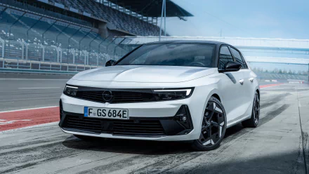 HD desktop wallpaper featuring a sleek white Opel Astra GSe, captured in a dynamic angle on a race track, highlighting its sporty design.
