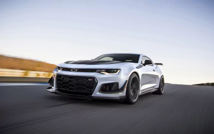 HD desktop wallpaper showcasing a Chevrolet Camaro ZL1 1LE in motion on a scenic road, highlighting the car's sleek design and powerful presence.