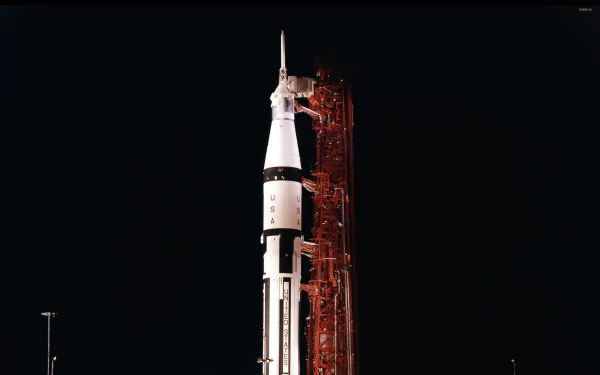 HD desktop wallpaper featuring the Saturn V rocket at night, poised for launch and illuminated against a dark sky.