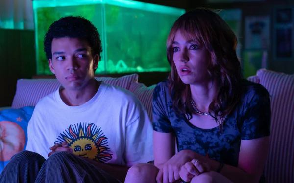 HD wallpaper of Justice Smith and Brigette Lundy-Paine in a scene from the movie I Saw the TV Glow, sitting together with a moody, neon-lit background.