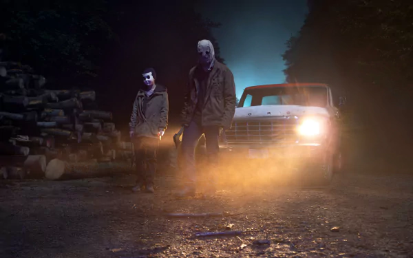 HD desktop wallpaper of The Strangers: Chapter 1 showing two masked figures standing ominously by a car with its headlights shining through the mist in a dark, forested area.