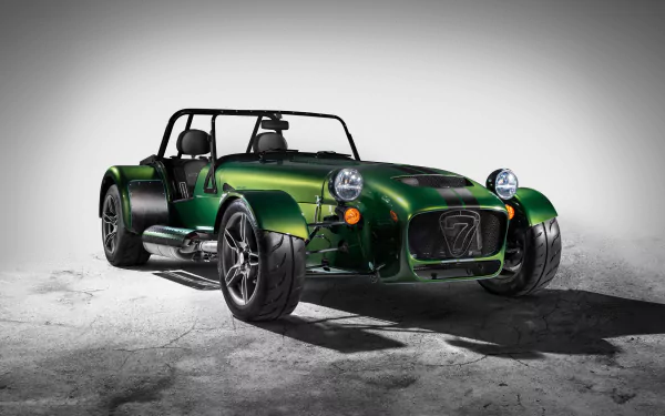 A high-definition desktop wallpaper featuring a green Caterham Seven 485 sports car against a neutral background.