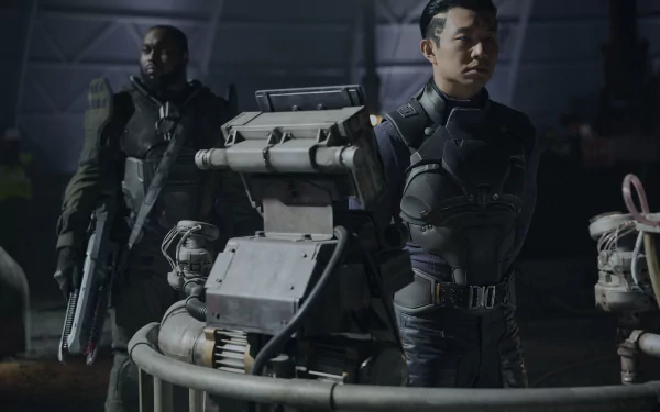 HD desktop wallpaper featuring a scene from the movie Atlas (2024), showing two individuals in futuristic attire standing behind a robotic machine in a dimly lit environment.
