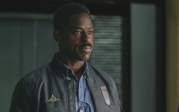 A still from the movie Atlas (2024), featuring a person looking thoughtful, wearing a jacket and shirt. This image is a high-definition desktop wallpaper and background.