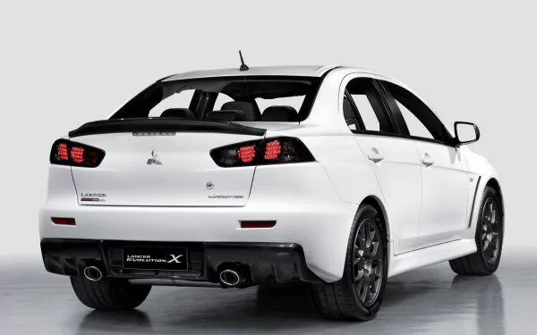 HD desktop wallpaper featuring a white Mitsubishi Lancer Evolution X from a rear three-quarter angle. The car's sporty design and bold rear lights are prominently displayed against a clean, neutral background.
