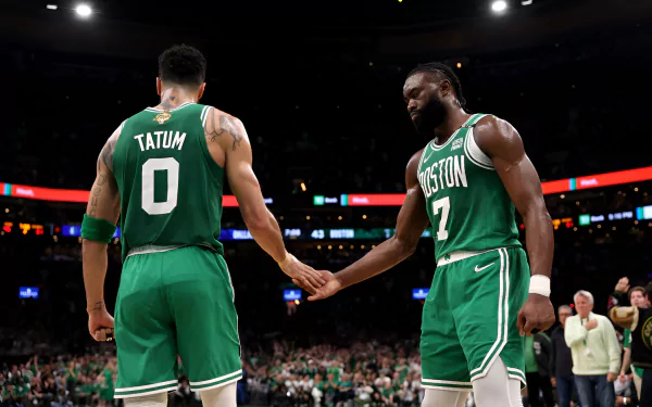 Boston Celtics players, Jayson Tatum and Jaylen Brown, share a moment on the basketball court in this HD desktop wallpaper. Both are in green uniforms with their names and numbers visible.