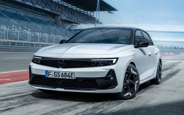 HD desktop wallpaper featuring a sleek white Opel Astra GSe, captured in a dynamic angle on a race track, highlighting its sporty design.