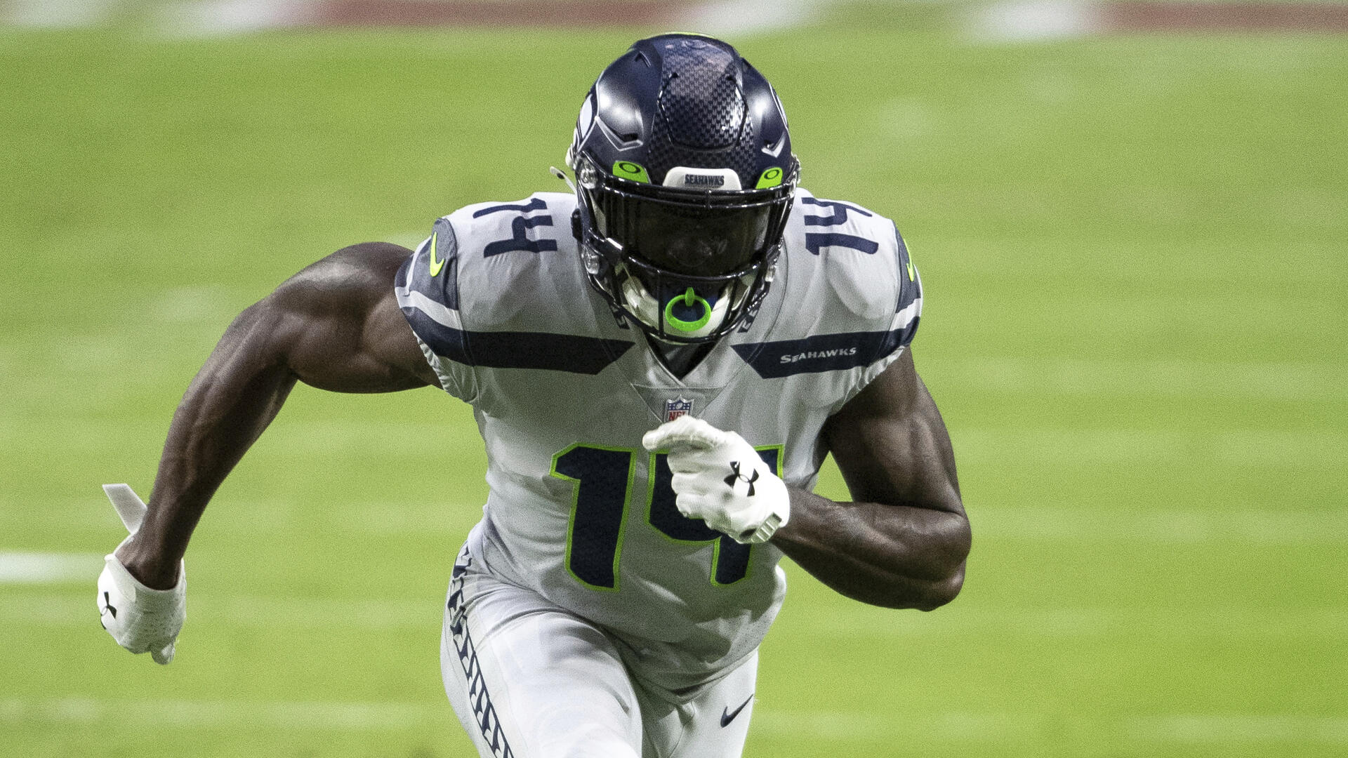 DK Metcalf of the Seattle Seahawks sprints down the field in action during an NFL game, captured in vibrant detail for a striking 4K Ultra HD desktop wallpaper.