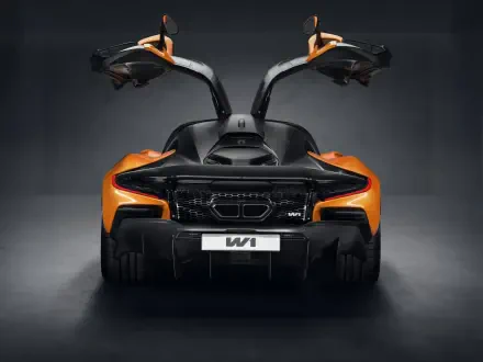 A striking view of a McLaren W1, showcasing its sleek design and distinctive gullwing doors against a dark background in this 8K Ultra HD wallpaper.