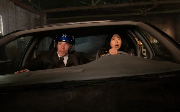 Two characters in a car with expressions of surprise and urgency, set in a dramatic scene from the movie Jackpot!. High-definition desktop wallpaper capturing their tense moment.