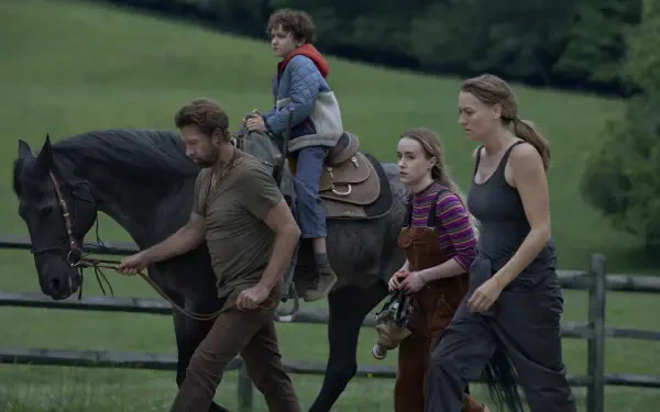 A scene from the TV show Teacup (2024) featuring Scott Speedman and Yvonne Strahovski, showing a family walking a horse in a lush, green landscape.