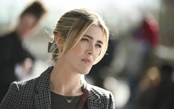 Melissa Roxburgh stars in the TV show Tracker (2024). This HD wallpaper features her in a thoughtful moment, set against a blurred urban background.