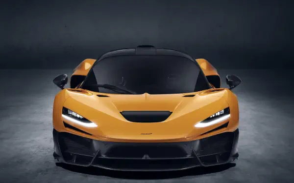 A stunning McLaren W1 in vibrant orange, showcased in a sleek studio setting, serves as an impressive 8K Ultra HD desktop wallpaper and background.