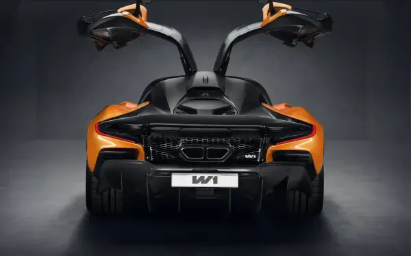 A striking view of a McLaren W1, showcasing its sleek design and distinctive gullwing doors against a dark background in this 8K Ultra HD wallpaper.