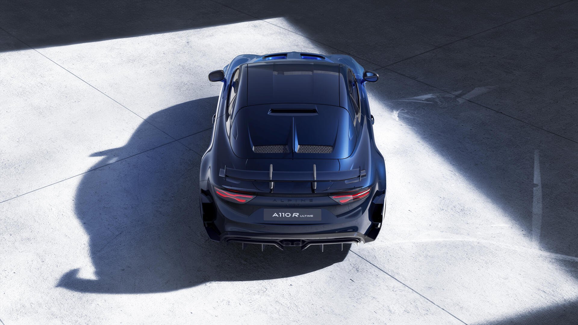 A striking Alpine A110 R Ultime car captured in a dramatic light, showcasing its sleek design. An 8K Ultra HD wallpaper for automotive enthusiasts.