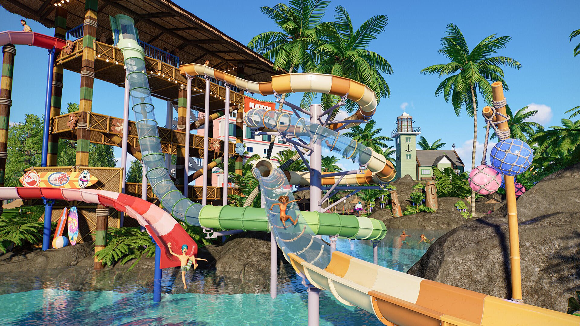 HD PC desktop wallpaper from the video game Planet Coaster 2, featuring a vibrant water park with colorful slides, palm trees, and tropical scenery.