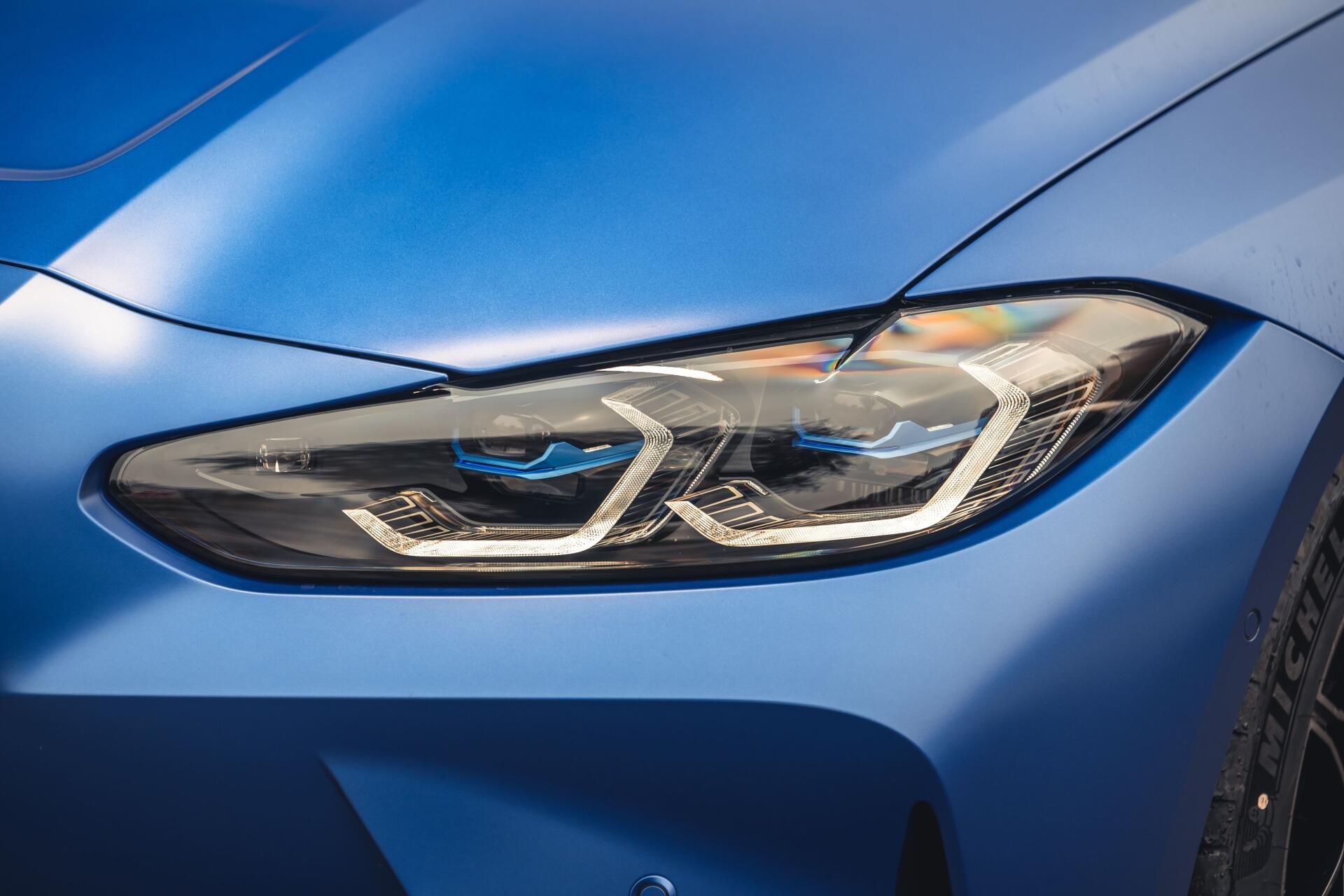 Close-up of a blue BMW headlight and sculpted front fender in 4K Ultra HD PC desktop wallpaper and background, showcasing LED daytime running lights and sporty body lines.