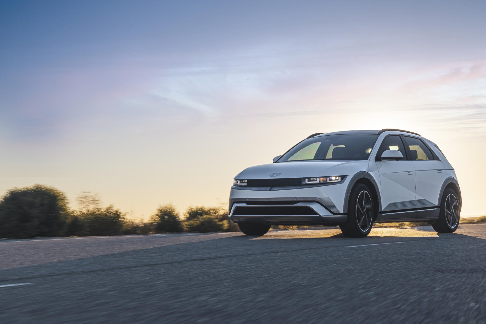 A sleek Hyundai IONIQ 5 car on an open road at sunset, showcased in vibrant 4K Ultra HD, highlighting its modern design and performance.