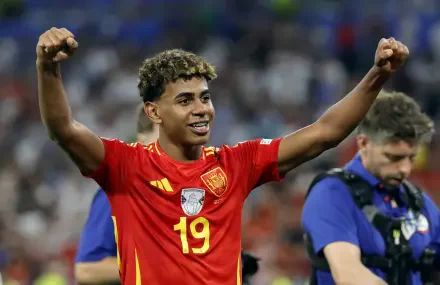 Lamine Yamal celebrates on the field, wearing the Spain National Football Team jersey number 19, capturing the spirit of soccer in this vibrant HD desktop wallpaper.