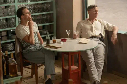 A captivating scene from a queer movie featuring Daniel Craig and Drew Starkey, enjoying drinks at a stylish table in a vibrant setting. A striking 4K Ultra HD desktop wallpaper.