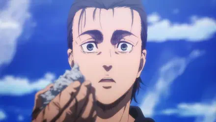 Eren Yeager from Attack on Titan: The Last Attack gazes intently while holding a small piece of rock, set against a backdrop of clear blue skies. HD anime wallpaper.