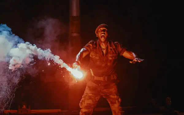 A dramatic scene from Jurassic World Rebirth, featuring a soldier wielding a flare amidst swirling smoke, showcasing intense action in stunning 4K Ultra HD.