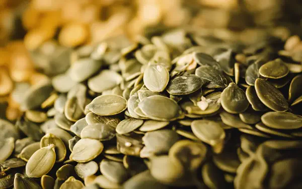 Close-up of pumpkin seeds, showcasing their texture and color variations. Rich in detail, this 4K Ultra HD image serves as an appealing desktop wallpaper.