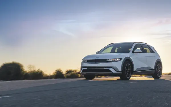 A sleek Hyundai IONIQ 5 car on an open road at sunset, showcased in vibrant 4K Ultra HD, highlighting its modern design and performance.