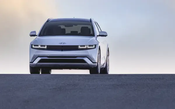 A sleek Hyundai IONIQ 5 showcases its modern design with sharp lines and distinctive headlights against a soft sky, captured in stunning 4K Ultra HD.