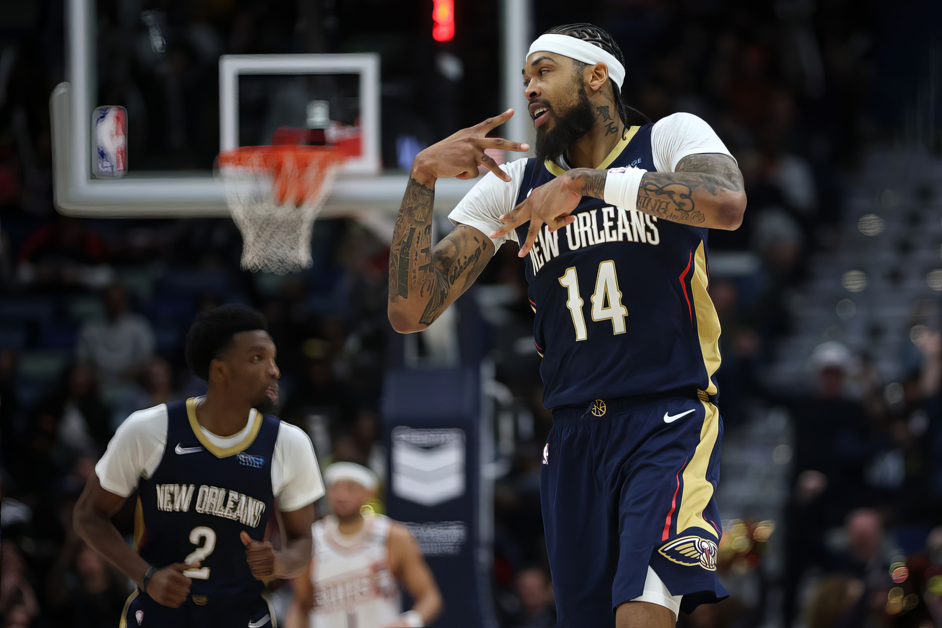 Brandon Ingram celebrates a play on the court, wearing the New Orleans Pelicans jersey, with teammates in the background during an NBA game. A dynamic sports wallpaper for fans.