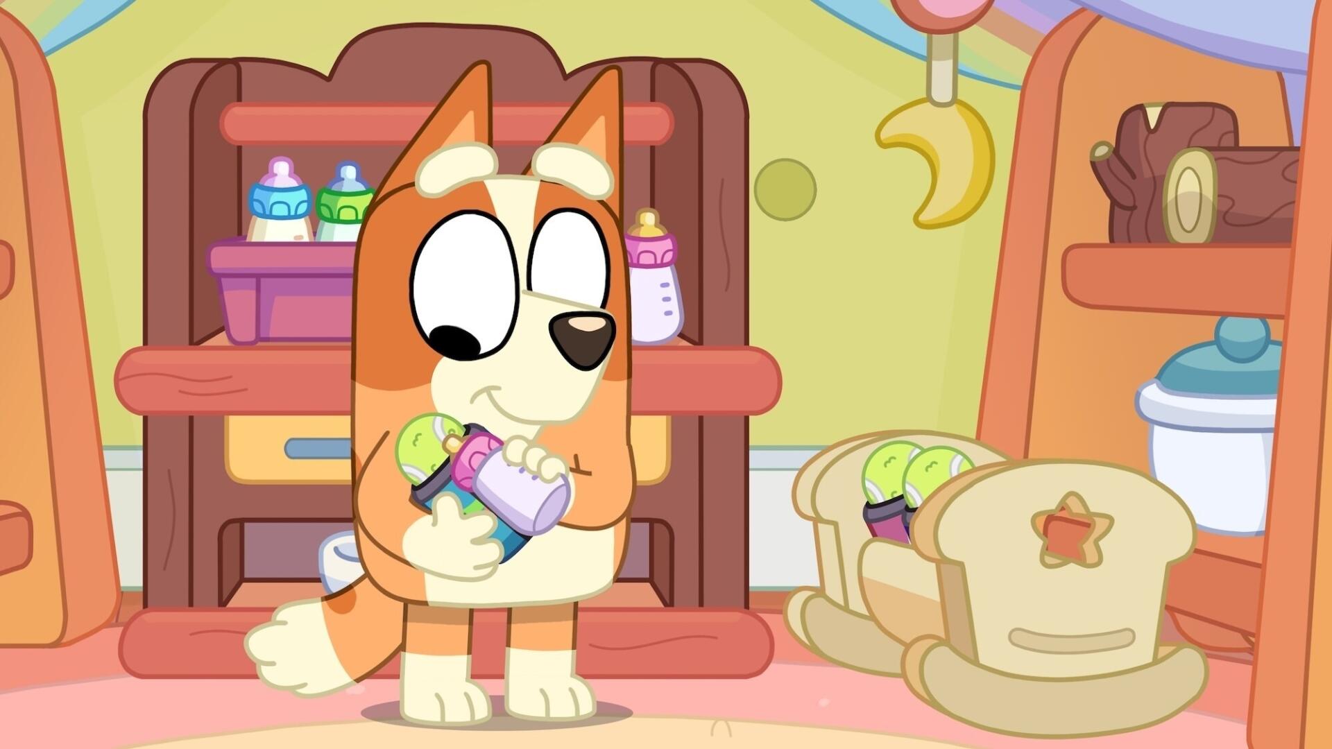 A charming HD wallpaper featuring Bluey, a playful cartoon dog, joyfully holding a bottle. The colorful background showcases a cozy playroom with toys and a crib.