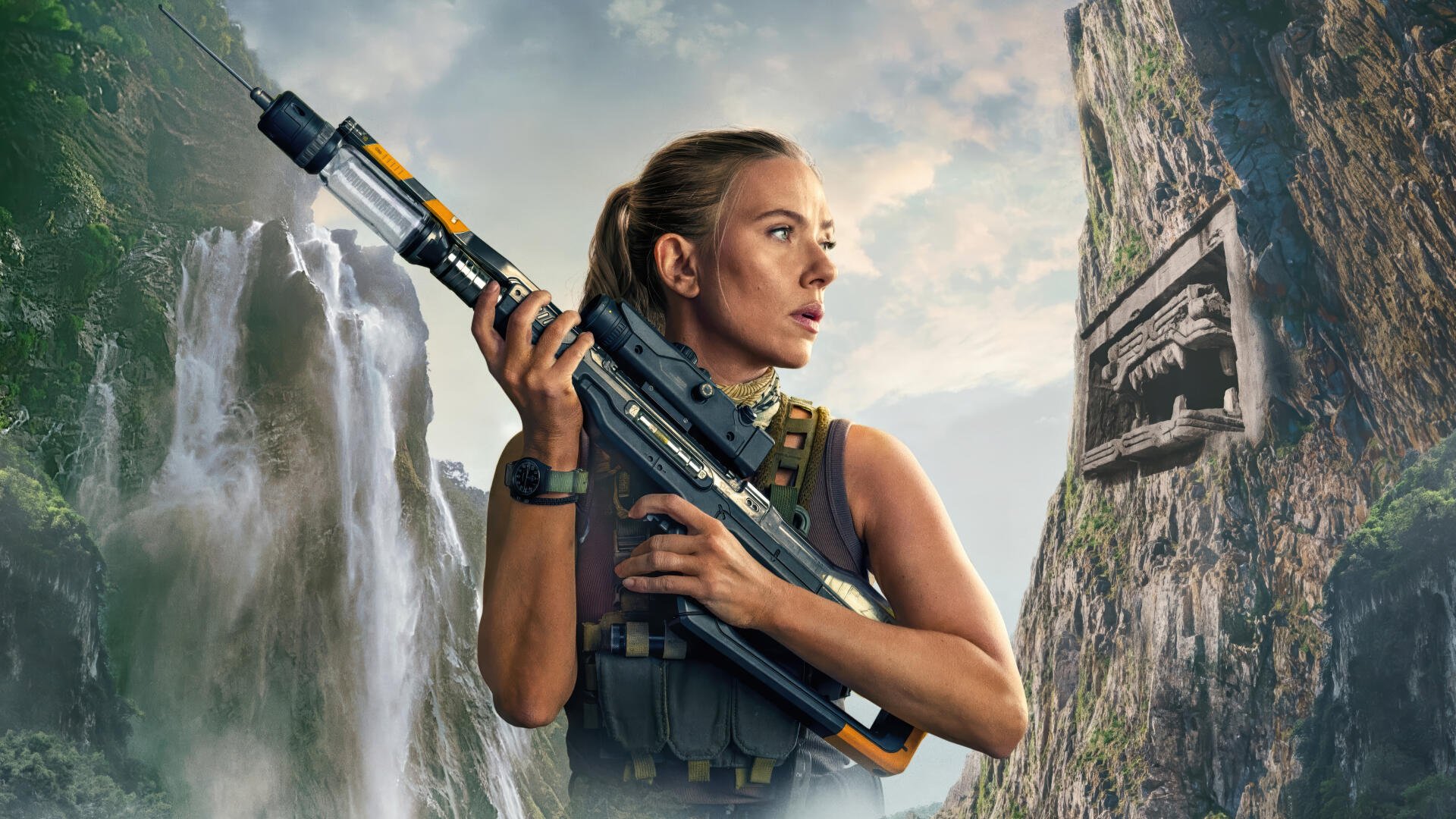 A focused woman holding a futuristic rifle stands against a backdrop of towering cliffs and waterfalls in this Jurassic World Rebirth 4K Ultra HD PC desktop wallpaper.