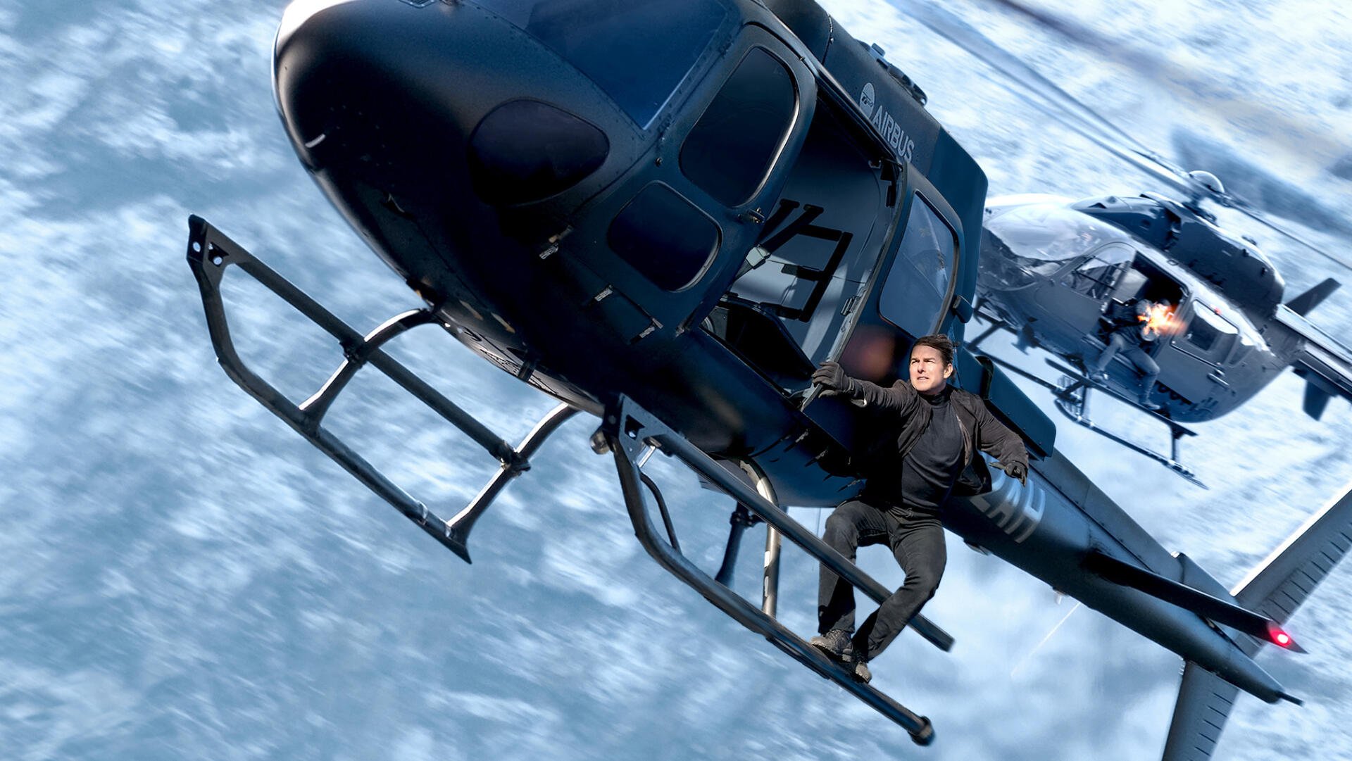 HD PC desktop wallpaper and background from Mission: Impossible - Fallout: the film's hero clinging to a black helicopter midair above clouds as another chopper closes in.