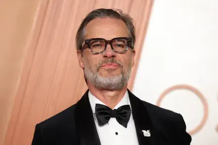 Guy Pearce at the Academy Awards, showcasing a sophisticated look in a tuxedo with glasses, set against an elegant backdrop. This 4K Ultra HD image enhances any desktop background.