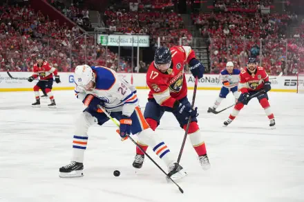 HD wallpaper showing intense NHL ice hockey action between the Edmonton Oilers and Carolina Panthers on a crowded rink during a game.