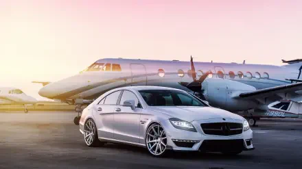 HD desktop wallpaper featuring a luxury silver Mercedes-Benz car parked in front of a private jet, symbolizing billionaire lifestyle and high-end travel.