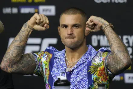 HD UFC desktop wallpaper featuring Dustin Poirier flexing his arms in a colorful shirt against a blurred fight event backdrop.