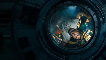 4K Ultra HD wallpaper featuring Ryan Gosling in a space module scene from the movie Project Hail Mary, viewed through a circular window with reflections.