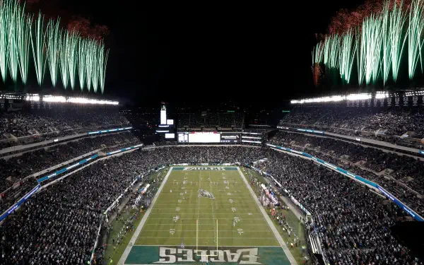 A vibrant view of the Philadelphia Eagles' stadium during a night game, filled with fans and illuminated by fireworks, showcasing the excitement of NFL football.