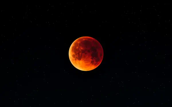A stunning 4K Ultra HD wallpaper featuring a lunar eclipse, with the moon glowing in deep orange against a starry night sky.