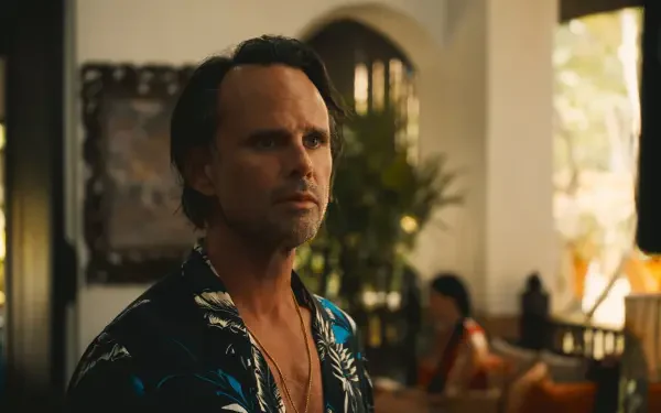 Walton Goggins in a scene from The White Lotus, wearing a floral shirt, with an expressive demeanor in a stylish, luxurious setting. HD desktop wallpaper showcasing the show's aesthetic.