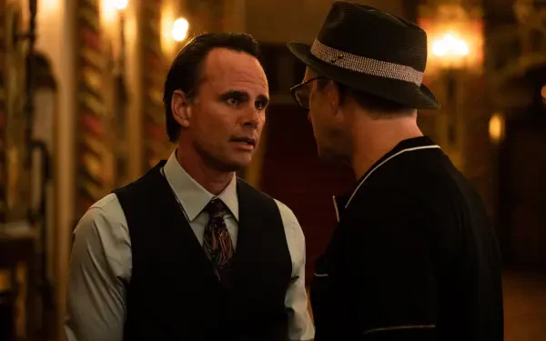 A dramatic scene from the movie Queen of the Ring, featuring Walton Goggins in a tense conversation, set against a richly detailed background. 4K Ultra HD wallpaper.