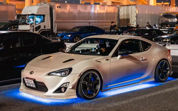 White Toyota GR 86 JDM car showcased with blue underglow lighting in a high-resolution 4K Ultra HD desktop wallpaper background.