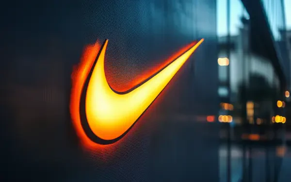 HD PC desktop wallpaper featuring a glowing orange Nike swoosh logo against a dark, blurred urban background.