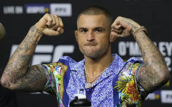 HD UFC desktop wallpaper featuring Dustin Poirier flexing his arms in a colorful shirt against a blurred fight event backdrop.