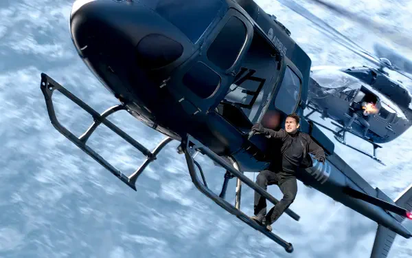HD PC desktop wallpaper and background from Mission: Impossible - Fallout: the film's hero clinging to a black helicopter midair above clouds as another chopper closes in.